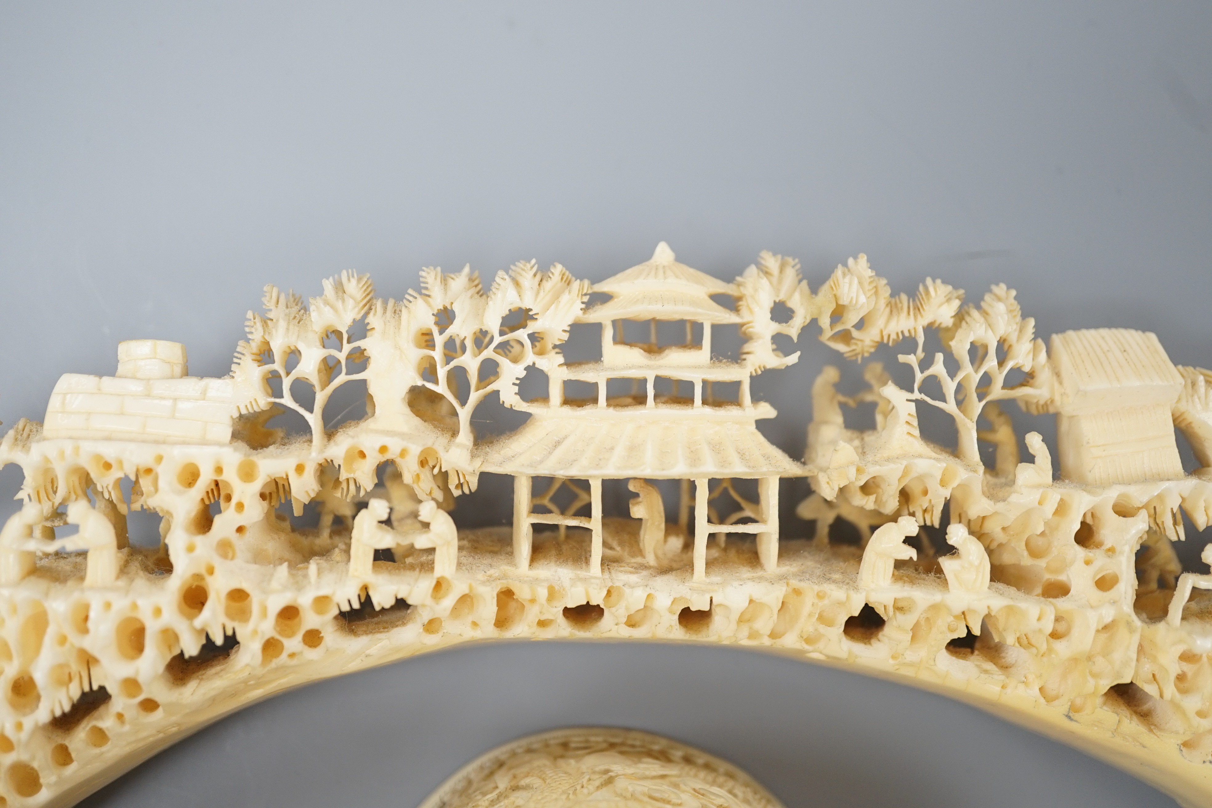 An early 20th century Chinese ivory ‘dragon’ box and cover, and a boar’s tusk carving of figures amid pavilions 40cm